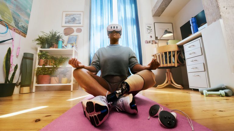 Eine Person sitzt im Schneidersitz auf einer Fitnessmatte. Vor den Augen trägt die Person eine Meta Quest 3.
